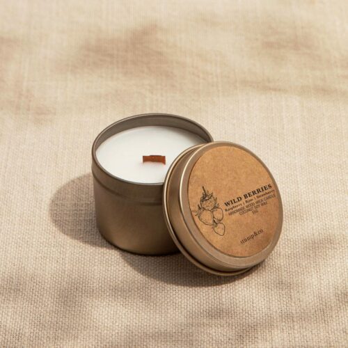 Tin Wooden Wick candles resting on beige linen cloth